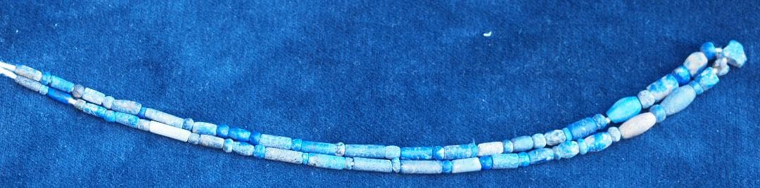 古代濃紺ラピスの管玉や丸玉をほぼ左右対称に編み、トップに斧型や多面体、80個の連